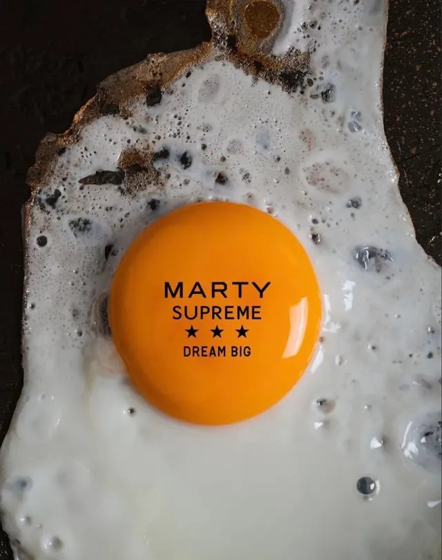 Fried egg with MARTY SUPREME branding on yolk, playful, photographic, vibrant
