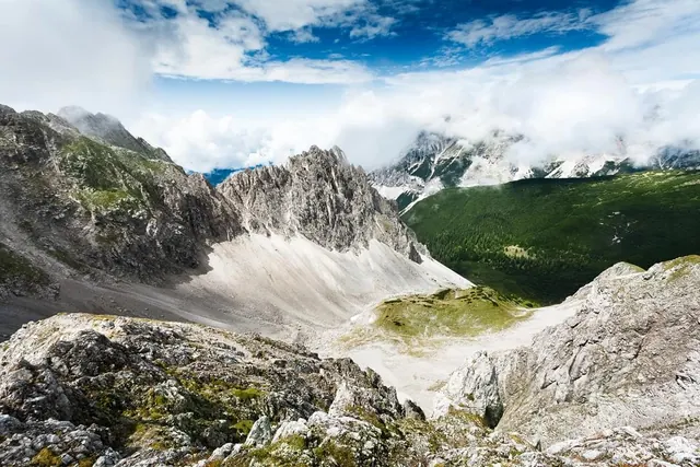 Jagged alpine peaks over green valley, photographic, cool