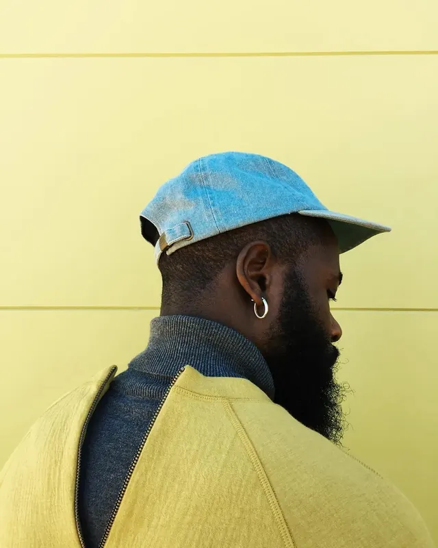 Portrait of a man in a blue hat and yellow garment
