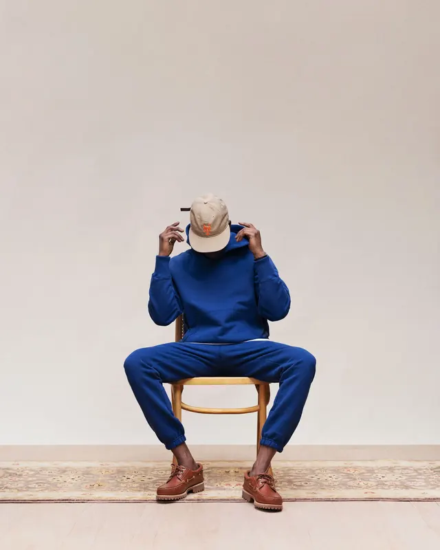 Person in Blue Sweater on Stool