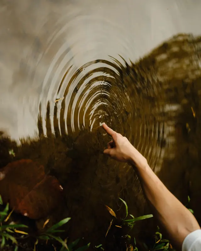 Hand Touching Rippled Water