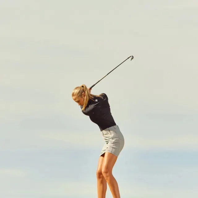 Woman Golfing on Beach