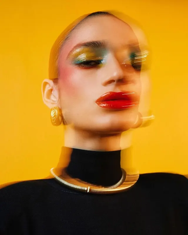 Motion-blurred beauty portrait with colorful makeup, photographic, editorial, vibrant