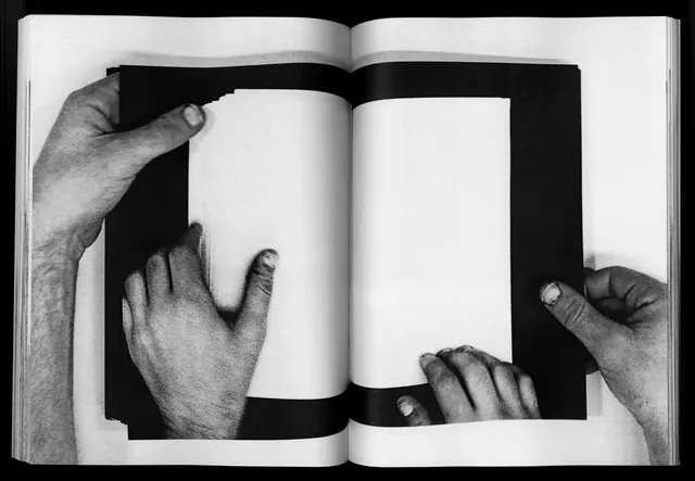 Hands interacting with open book