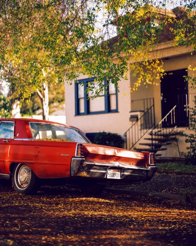 Vintage Red Sedan in Autumnal Setting