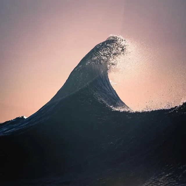 Curling ocean wave at sunset, photographic, dark