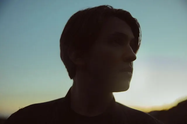 Backlit profile silhouette at twilight, minimal, photographic, dark