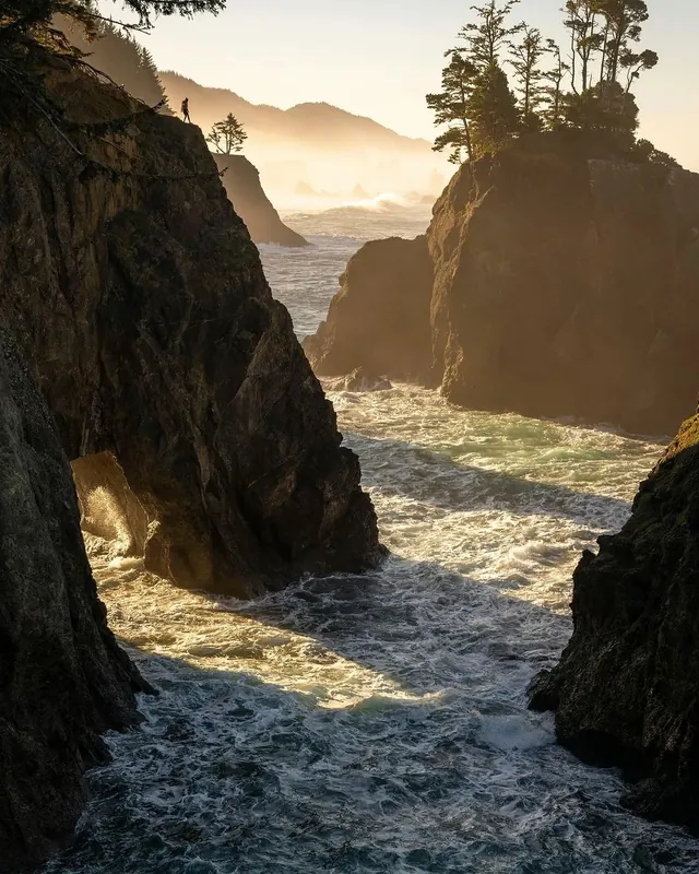 Golden hour coastal cliffs with lone figure, photographic, warm