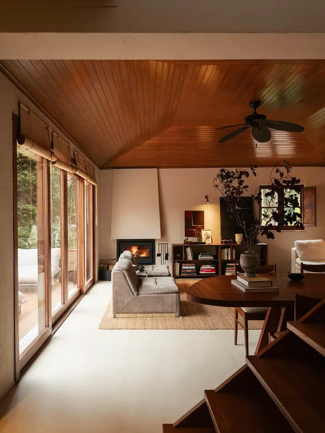 Warm wood cabin interior with fireplace and forest view, photographic, organic, warm