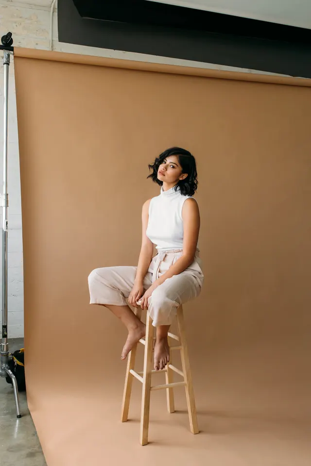 Minimal fashion portrait on tan backdrop, photographic, minimal, warm