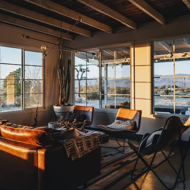 Modern interior with leather sofa and mountain views, photographic, minimalist, warm