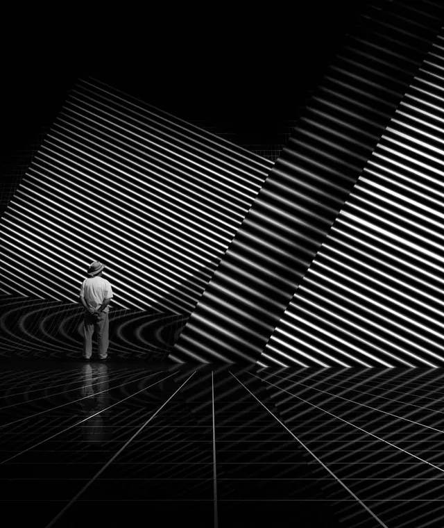 Man in striped light installation art space, photographic, minimalist, monochrome
