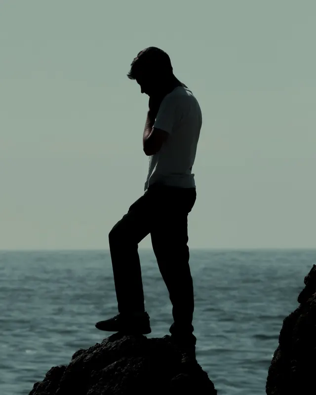 Silhouette of a Person on a Rock