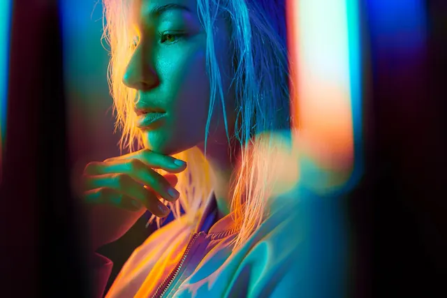 Woman portrait with split blue and orange neon lighting, photographic, dark