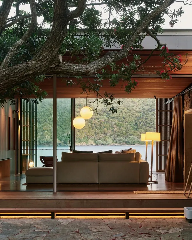 Modern lakeside cabin interior with indoor tree branch, minimal, organic, warm