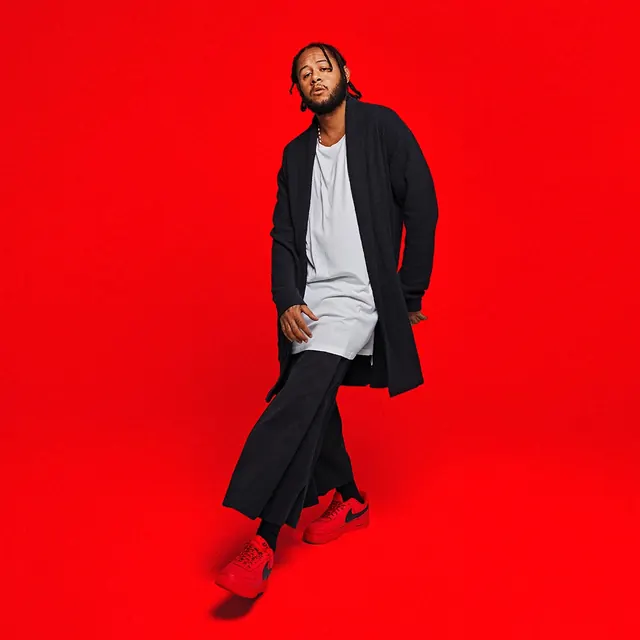 Man in Black and White Outfit on Red Background