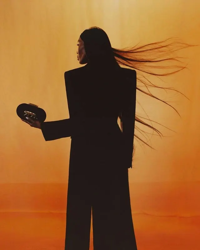 Backlit fashion silhouette on orange, photographic, minimal, warm