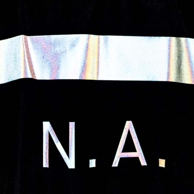 Iridescent N.A. applique on black fabric, minimal, technical, dark
