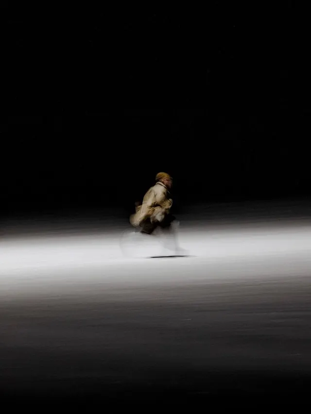 Motion-blur cyclist at night, minimal, monochrome, dark