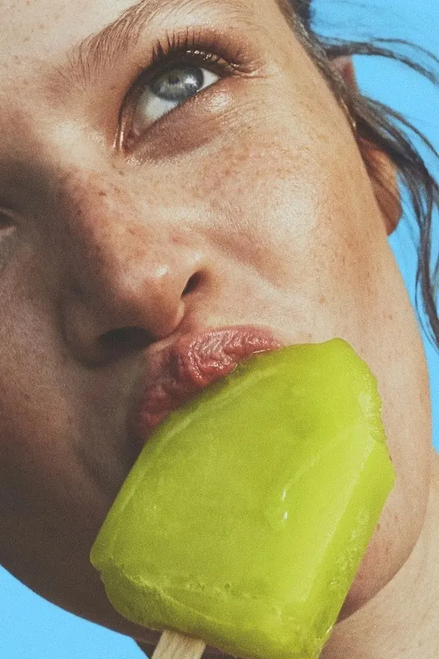 Green popsicle close-up portrait, photographic, playful, vibrant