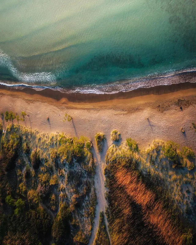 Aerial beach dunes and turquoise water, photographic, minimal, warm