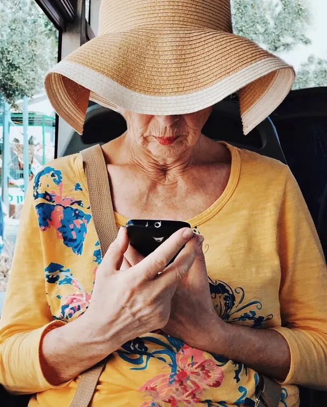 Woman in Straw Hat Holding Smartphone