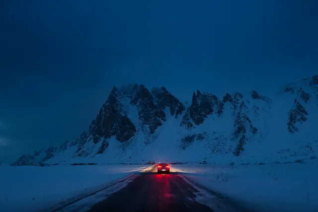 Car on snowy road at blue hour, photographic, minimal, cool