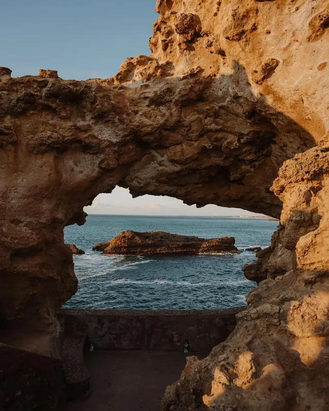 Coastal rock arch golden hour, photographic, organic, warm