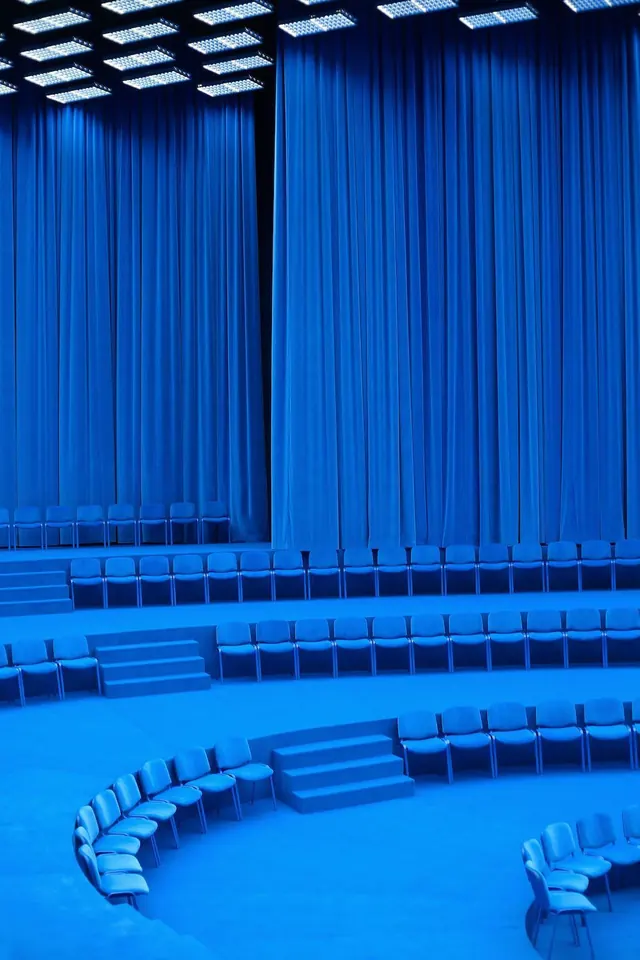 Monochrome blue fashion show seating, minimal, photographic, vibrant