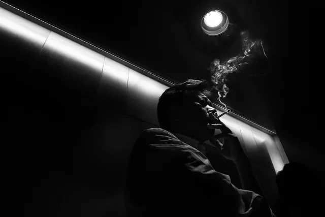 Film-noir smoke portrait low angle, photographic, editorial, monochrome