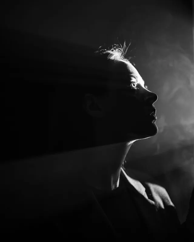 Black-and-white smoke profile portrait, photographic, editorial, monochrome
