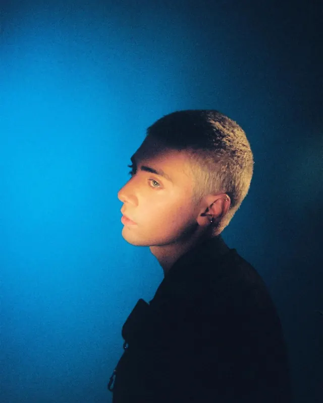 Blue-orange profile buzz cut portrait, photographic, editorial, dark