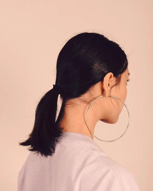 Oversized gold hoop earring back portrait, photographic, minimal, light
