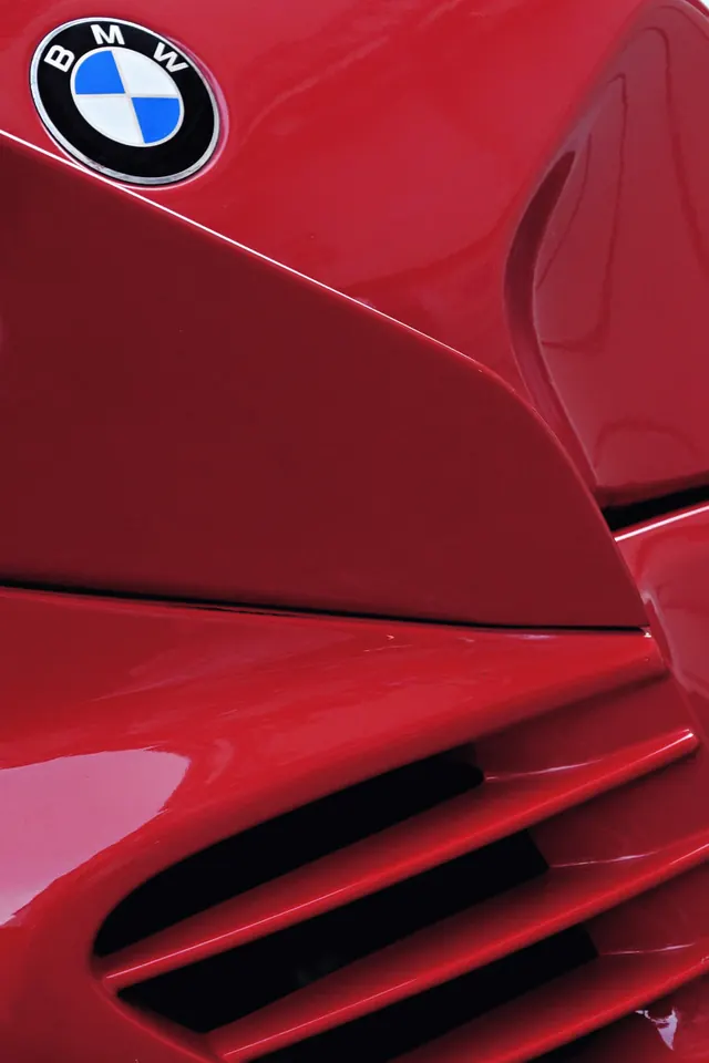 Red BMW bodywork detail close-up, photographic, luxury, vibrant