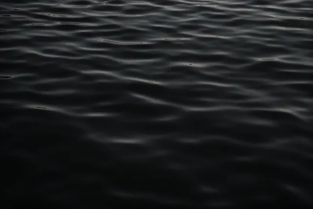Dark rippling water surface, minimal, photographic, dark