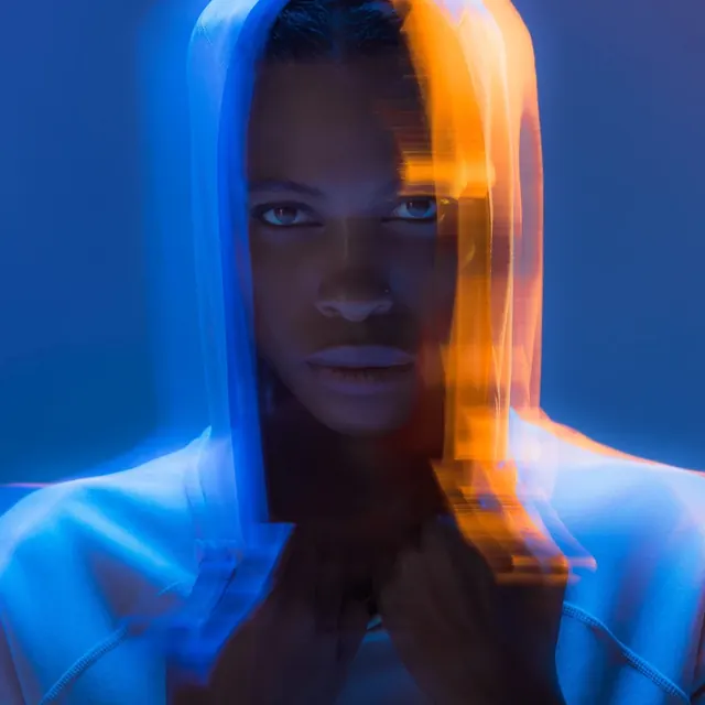 Studio portrait with blue and orange motion lighting, photographic, dark