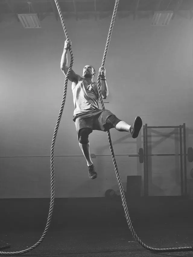 Nike athlete climbing rope—dynamic monochrome action shot, photographic, monochrome, monochrome