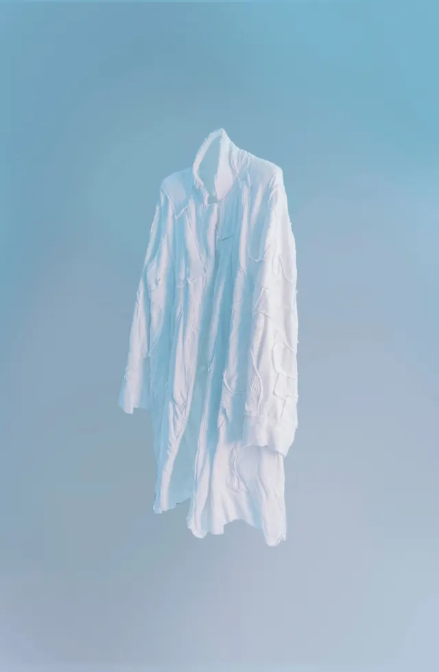 Floating textured white coat on blue, minimal, photographic, light