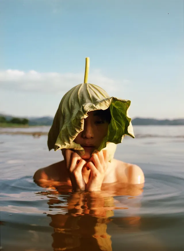 Portrait with lotus leaf hat in water, organic, photographic, warm