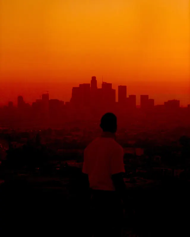 Cinematic orange sunset city skyline silhouette, photographic, vibrant