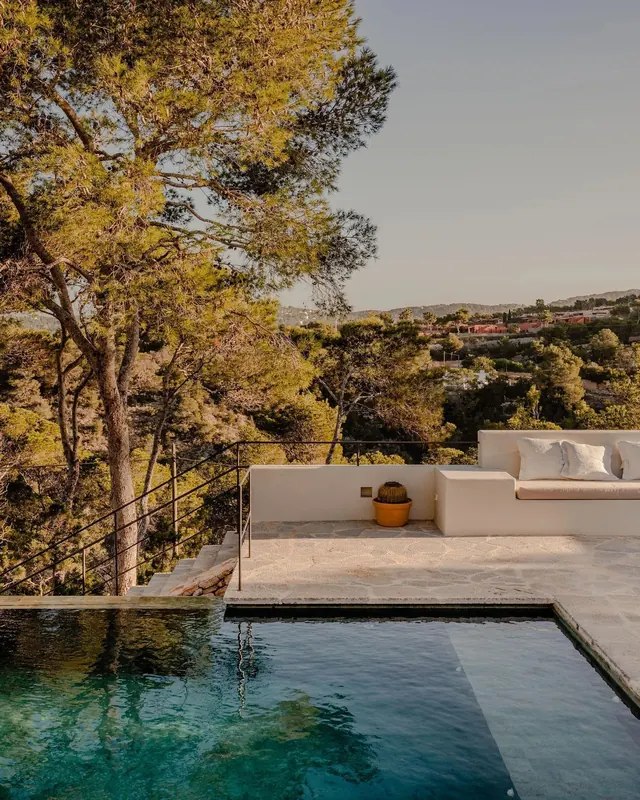 Infinity pool terrace overlooking Mediterranean hills, minimal, photographic, warm
