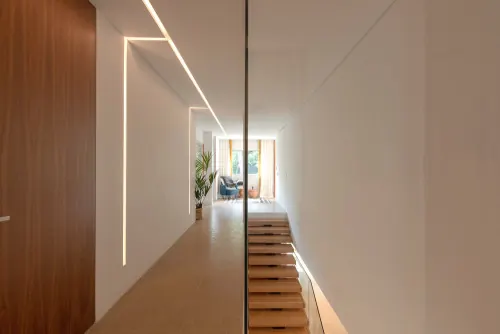 Minimalist wooden hallway with linear ceiling light, minimal, light-mode, warm