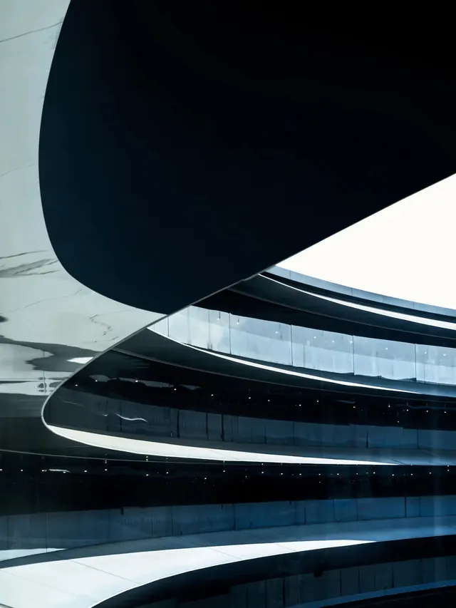 Curved building facade detail with spiral forms, photographic, architectural, dark