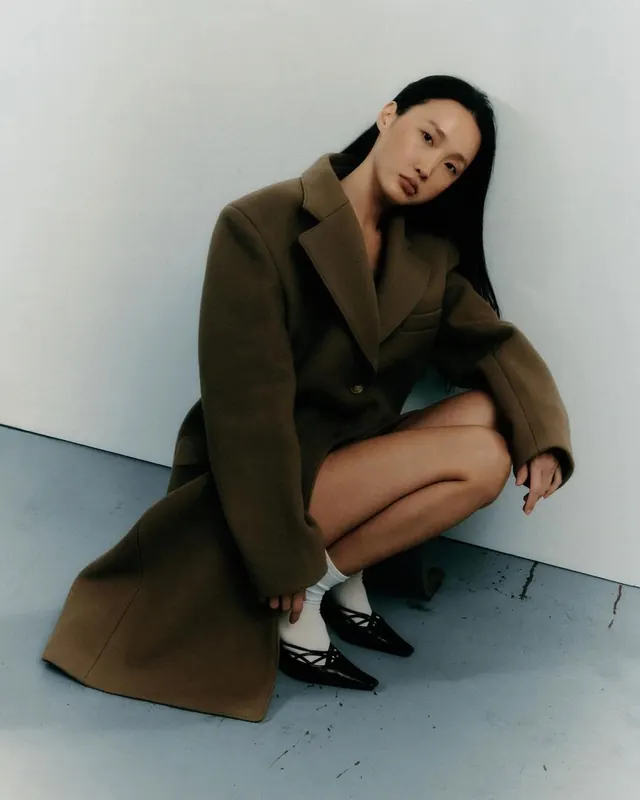 Portrait of woman in oversized blazer, photographic, minimal, warm