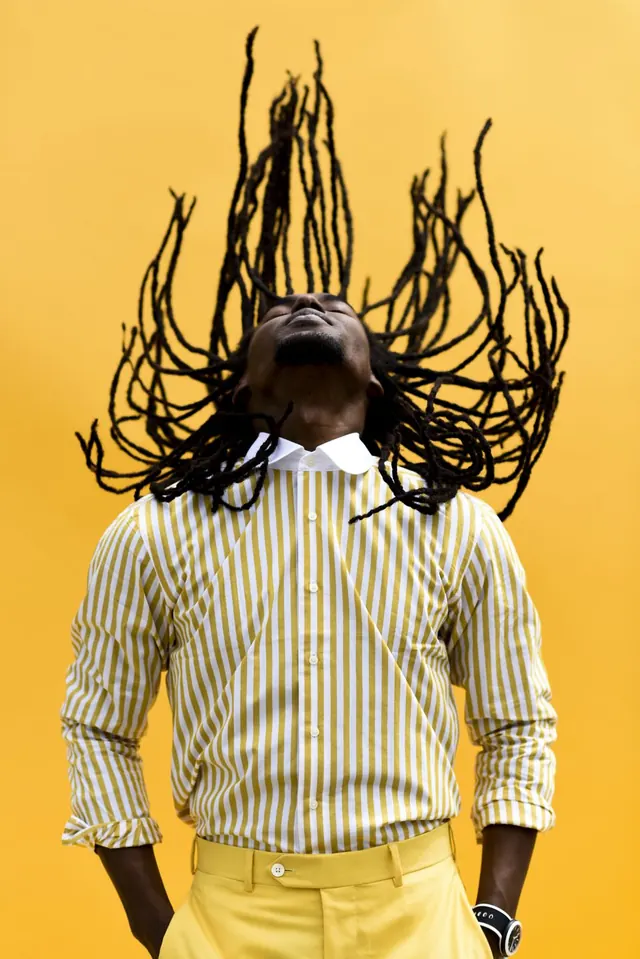 Portrait with dynamic line-art hair against yellow background, photographic, playful, warm