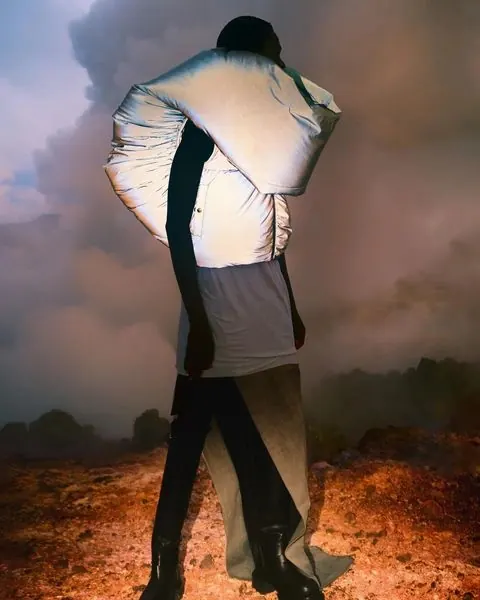 Figure with illuminated fabric against landscape, photographic, surreal, warm