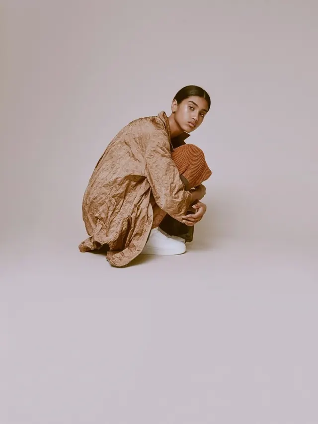 Studio portrait with oversized fabric, photographic, organic, warm