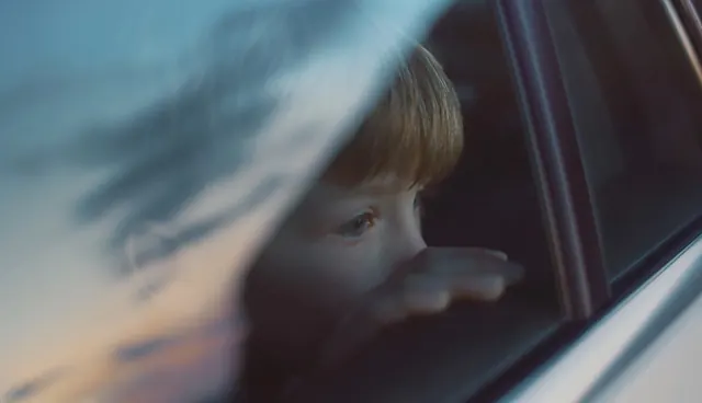 Blurred child at car window, photographic, editorial, cool