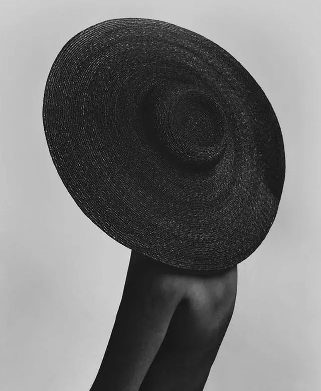 Oversized black woven hat portrait, photographic, minimalist, monochrome
