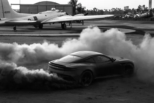 Black and white sports car with aircraft hangar, photographic, monochrome, dark